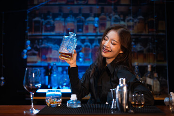 Beautiful young woman drinking alcohol at nightclub bar enjoying a pub party