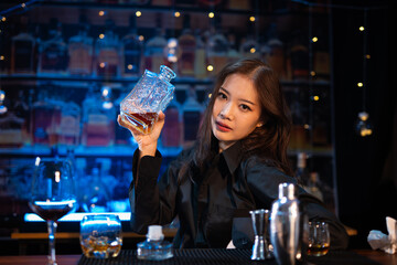 Beautiful young woman drinking alcohol at nightclub bar enjoying a pub party