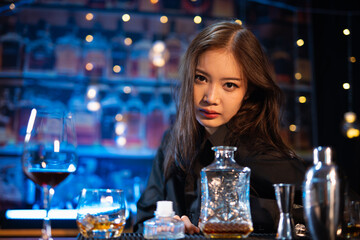 Beautiful young woman drinking alcohol at nightclub bar enjoying a pub party