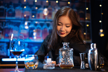Beautiful young woman drinking alcohol at nightclub bar enjoying a pub party