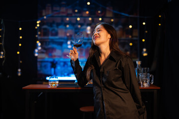 Beautiful young woman drinking alcohol at nightclub bar enjoying a pub party