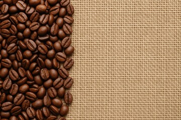 Coffee beans resting on a textured canvas surface