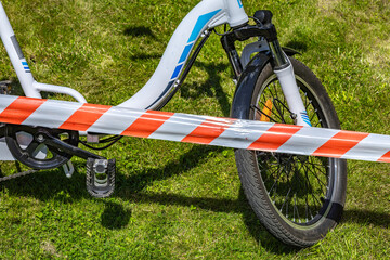 The scene of a bicycle accident surrounded by red and white warning tape, a cyclist's accident,
