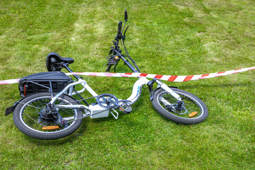 The scene of a bicycle accident surrounded by red and white warning tape, a cyclist's accident,