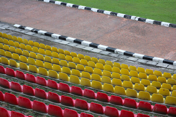 Empty stadium seats in vibrant yellow and red colors, geometric rows, sports arena background,...