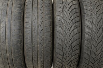 Used and weathered car tires displayed on a white background for tire shop advertising