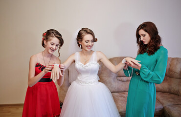 Three women are getting ready for a wedding
