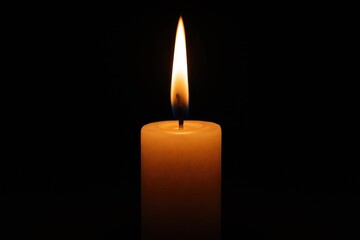 A lone candle flickering in darkness