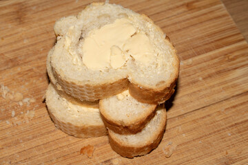 Sliced and buttered French stick baguette bread ready for dinner food prep with knife