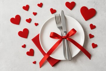 Valentine's Day dinner arrangement adorned with heart motifs on a white and gray concrete surface