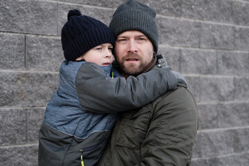 Father and son walking down on sidewalk together. Portrait of a handsome middle-aged man with...