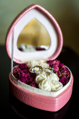 Floral ring box design. Elegant ring box filled with dried roses and rings, displayed on a dark...