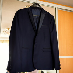 Elegant dark blazer hanging at home. A stylish dark blazer is neatly hung in a well-lit room, ready...