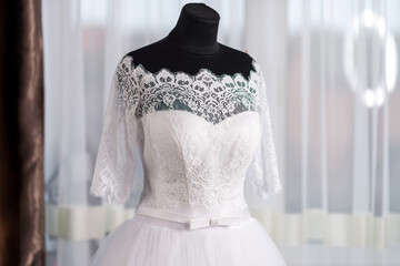 Bridal gown on display. A beautiful white wedding dress with lace details is showcased on a...