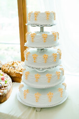 White cake with orange accents. A stunning five-tier white cake with delicate orange decorations...