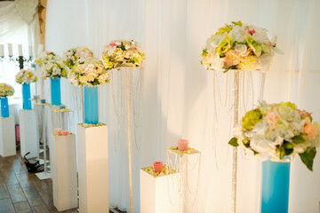 Wedding floral elegance. Beautiful floral displays on stands enhance the wedding atmosphere with soft lighting and pastel colors.