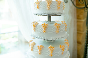 Yellow-decorated wedding cake. A stunning three-tier wedding cake with delicate yellow flowers,...