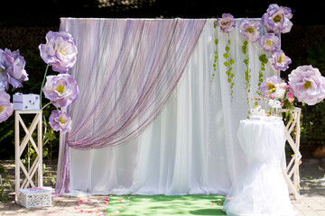 Floral backdrop for events. Bright and elegant floral backdrop with purple flowers and drapes, ideal for a festive gathering or photo opportunity.