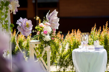 Spring outdoor wedding decor. Beautiful floral arrangement with pastel colors set up for a spring wedding celebration in a garden.