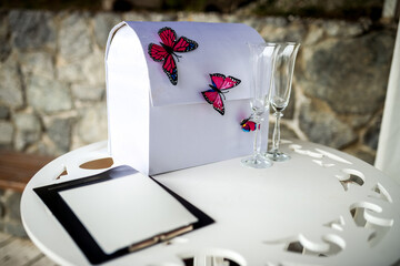 Butterfly wedding card box. A stylish wedding card box adorned with butterflies sits on a table...
