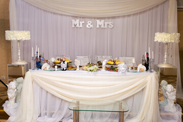 Elegant wedding reception table setting. A stunning wedding table with gourmet dishes, candles, and...