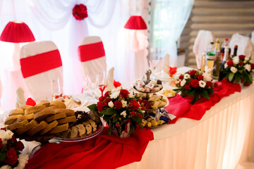 Chic table setup for events. Brightly decorated table features a variety of foods, elegant flowers,...