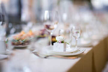 Elegant dining setup with floral accents. Table elegantly set with fine dining ware and delicate...