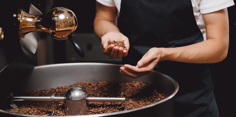 Coffee roasting machine on small business factory, Worker hold fresh hot beans