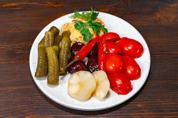 Colorful array of pickled vegetables served on a white plate highlighting freshness and unique...