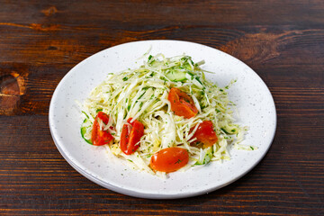 Fresh cucumber and tomato salad served on a rustic wooden table during a summer lunch