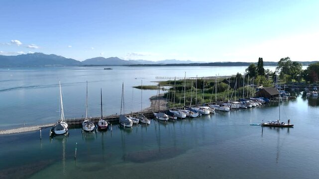 Wundervolle Sommerlandschaft am Chiemsee aus der Drohnenperspektive mit Seegelboten im Hafen