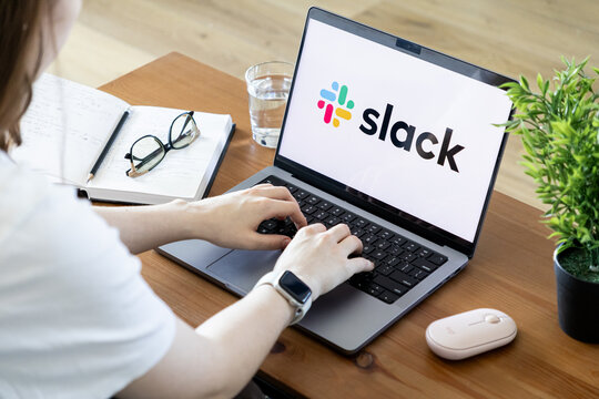 Poznan, Poland - June 15, 2025: Slack communication platform displayed on a laptop, utilized by a person for effective virtual collaboration in a modern office