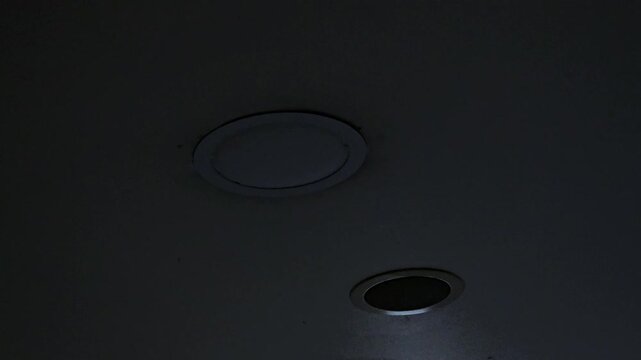 bright, circular recessed light fixture emitting an intense, almost blinding white glow from a light-colored ceiling.