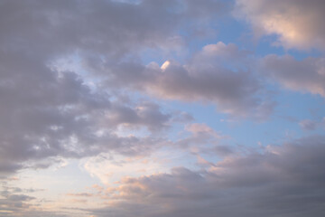 Soft pastel clouds in blue evening sky.