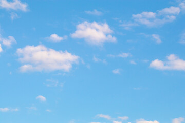 Soft pastel clouds in blue evening sky.