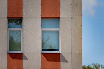 modern building facade with geometric design concrete and red vertical stripes featuring two closed...