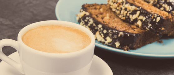 Fresh baked pastry made of zucchini and cup of white coffee. Delicious dessert. Vintage photo