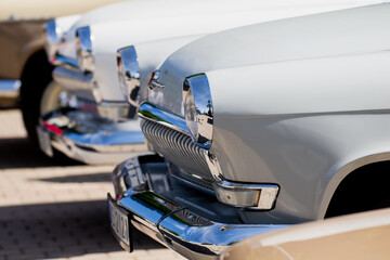 front view lineup of vintage retro soviet cars with shiny chrome bumpers and beige white classic...