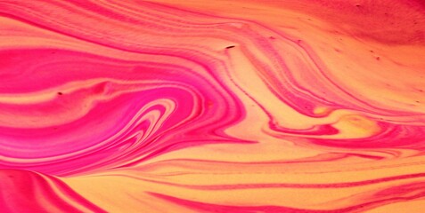 Orange-scarlet abstract background. Waves of paint flow freely and create a unique pattern.
