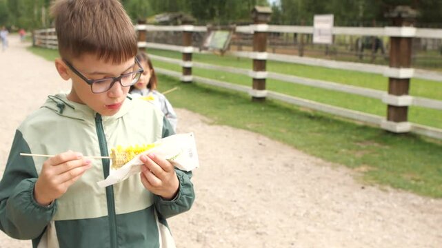 Boy eating corn on the cob at a farm
