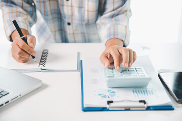 Accountant working on desk using calculator for calculate finance report in office. business...