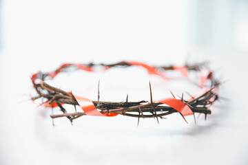 Crown of thorns on white table background. Easter, central celebration in Christianity, honors...