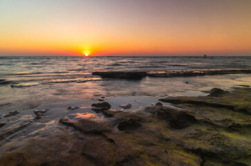 sunset over the rocky shoreline in Israel