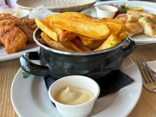 Crispy golden french fries with sauce at Kop Van de Haven Restaurant, Netherlands