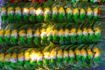 Close-up view of prepared paan leaves with colorful toppings, arranged neatly in rows, showcasing...