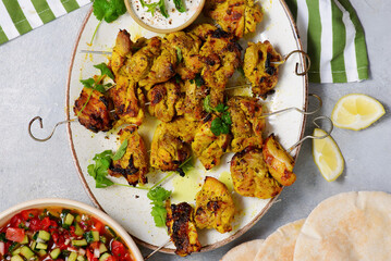 Persian chicken kebab with yogurt sauce, pitas and shiraz vegetable salad.selective focus