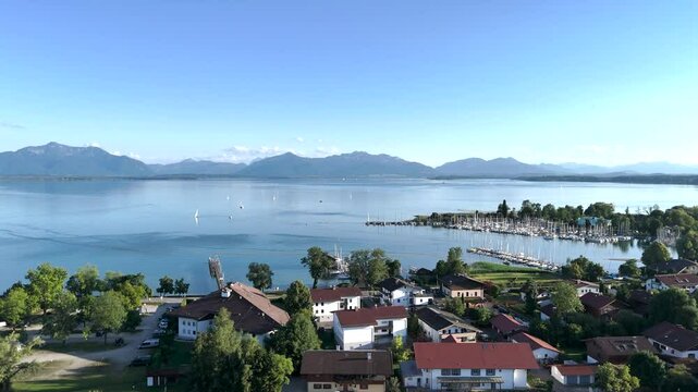 Wundervolle Sommerlandschaft am Chiemsee aus der Drohnenperspektive mit Seegelboten im Hafen