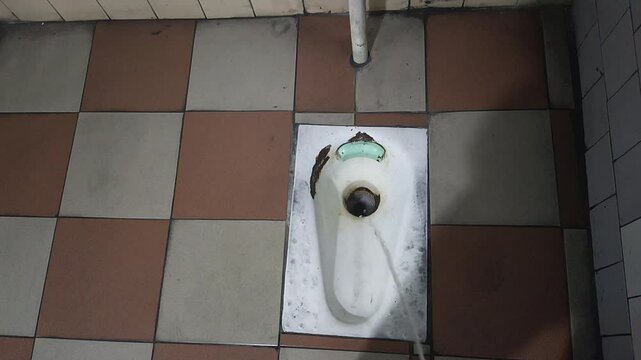 Overhead view of a man urinating into a toilet bowl.
