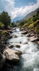Mountain river cascades through lush green valley under a sunny sky