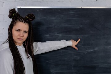An engaged instructor is pointing at a blank chalkboard for various educational purposes